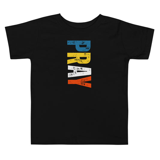 Toddler t-shirt with bold block lettering “Pray” in blue, yellow, white, and orange, promoting faith, strength, and confidence.